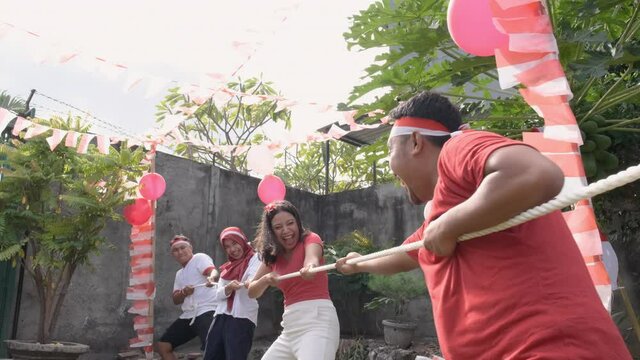 three people in one team tried to pull the rope hard during the tug-of-war competition at Indonesia's Independence Day celebrations