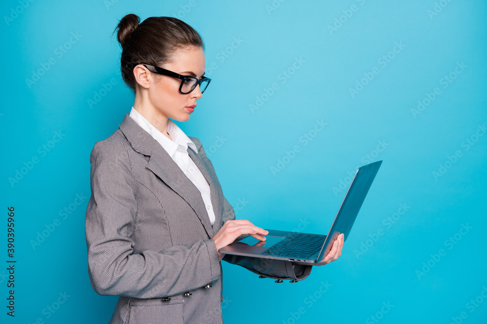 Poster profile side view of attractive focused busy lady holding in hand using laptop isolated over bright 