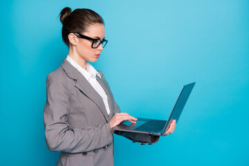 Profile side view of attractive focused busy lady holding in hand using laptop isolated over bright...