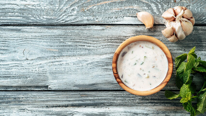 Authentic pakistani cucumber raita sauce on gray wooden background. Raita sauce dip with cucumber,...