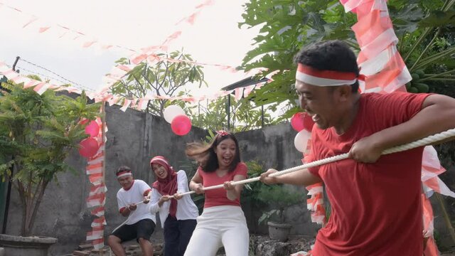 three people in one team tried to pull the rope hard during the tug-of-war competition at Indonesia's Independence Day celebrations