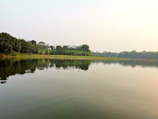 Beautiful village lake in different angle. It is in Bangladesh.  The length of the lake is about two kilometers. The depth of the lake is about 50 feet. It looks very beautiful during the sun set.