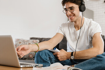 Handsome man indoors at home using laptop computer