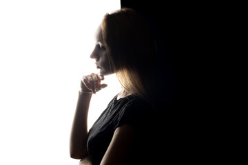 Portrait of beautiful young woman on a contrasty black and white background.