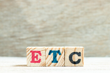 Alphabet letter in word etc (abbreviation of et cetera) on wood background