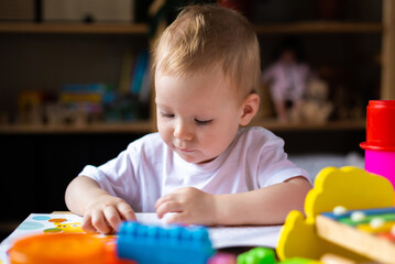 Cute little girl playing alone with many colorful toys