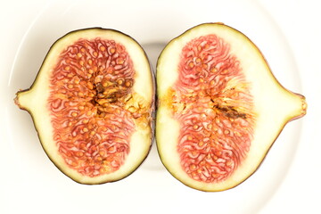 Ripe dark blue organic figs, close-up, on a ceramic plate.