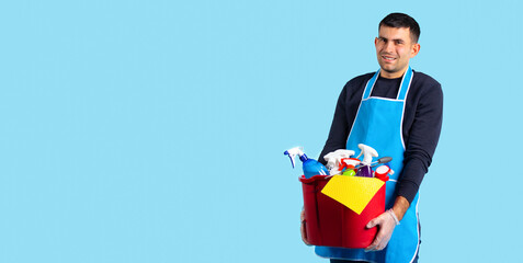 Banner, long format. Close-up of a Caucasian man holding a lot of cleaning products in a bucket...