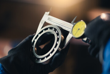 the abstract image of the technician maturing the ball bearing in the industrial factory.