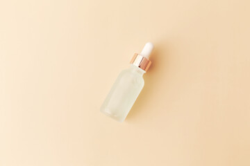 Glass bottle with pipette on white background. Top view, flat lay, copy space.
