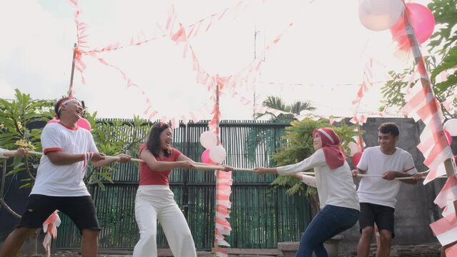 three people in one team tried to pull the rope hard during the tug-of-war competition at Indonesia's Independence Day celebrations