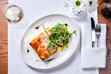 Lasagne bolognese in a plate on a table.