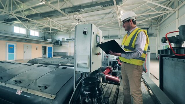 Male worker is managing indoors wastewater facilities