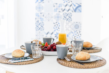 Plate with fresh crusty bread and glass of juice on grey plate