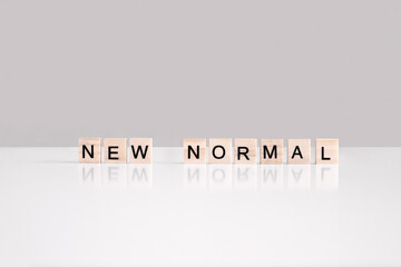 New normal phrase made of wooden letters cubes side view. Life after covid-19 pandemic with social...