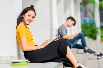 Young girl watching tablet sitting on the stairs in the city.