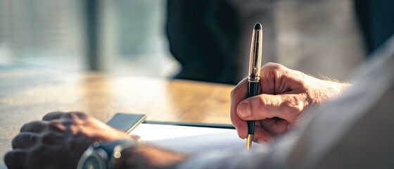 Closeup Businessman signing a contract investment professional document agreement on the table with...