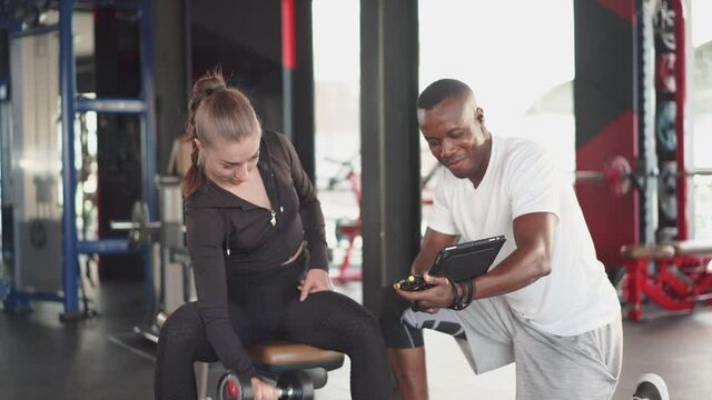 Personal trainer and sport woman at gym