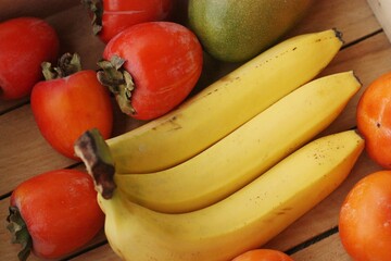 Obraz na płótnie Canvas Juicy persimmons bananas and mango close up 