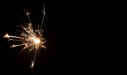 Burning sparkler on a black background with place for text. New year, birthday