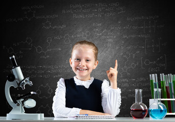 Little girl scientist sitting at desk