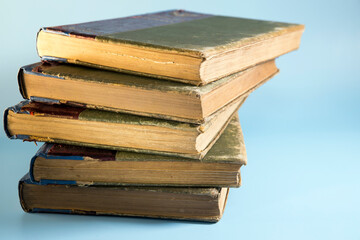 pile of vintage books isolated on blue background. Flat lay, top view. Copy space. Back to school.