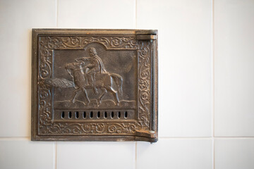 Antique damper in the Russian stove with the image of a horseman