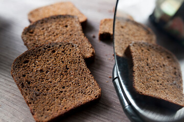 Sliced rye bread on cutting board. Whole grain rye bread with seeds on rustic background
