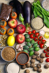 A set of useful products for a healthy diet. Vegetables, fruits, herbs, seeds. Cherry tomatoes, lemon, apples, persimmons, feijoa, quinoa, flaxseeds, buckwheat, walnuts, garlic, tea seeds, spinach.