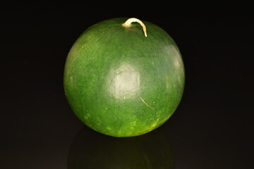 Ripe organic watermelons, close-up, on a black background.