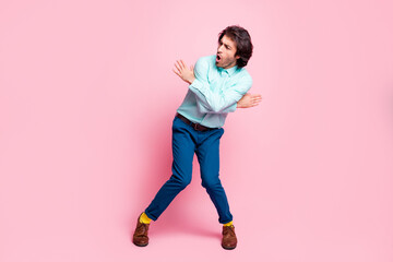 Full body photo of young handsome man enjoy music dance look empty space isolated over pink color background