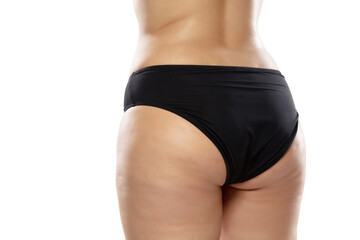 Back view. Overweight woman with fat cellulite legs and buttocks, obesity female body in black underwear isolated on white background. Orange peel skin, liposuction, healthcare and beauty treatment.