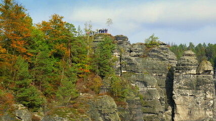 Bastei mit Menschen im Nationalpark Sächsische Schweiz mit vielen Felsen und Bäumen im Herbst