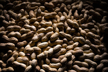 Obraz premium group of peanuts close up. peanuts as a background. peanuts with dramatic light.
