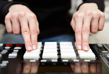 Hip hop music producer playing new beats with professional midi controller device on sound...