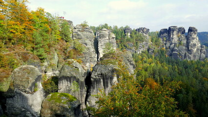 Bastei mit Menschen im Nationalpark Sächsische Schweiz mit vielen Felsen und Bäumen im Herbst