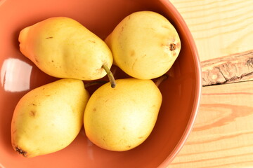 Ripe organic yellow-red pears, close-up, on a ceramic plate.