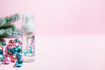 Mockup with transparent bottle of liquid cosmetic product oil or cleaning lotion with winter new year decorations