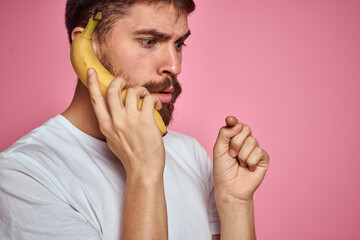 bearded man with banana in hand on pink background fun emotions model