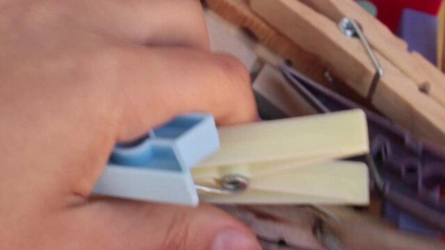 Close up of a girl taking some colthes pin from a basket