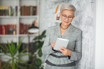 beautiful stylish adult woman in suit with tablet