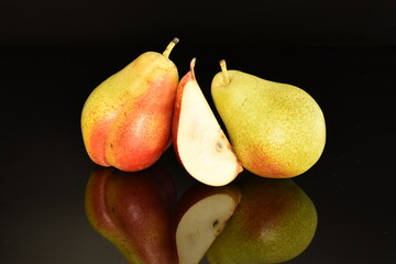 Fototapeta na wymiar Ripe organic yellow-red pears, close-up, on a black background.