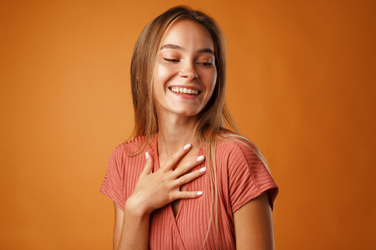 Peaceful Young Blonde Woman Holding Hands On Her Chest.