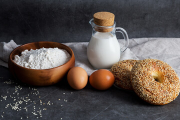 Flour, milk, eggs at dark background. Ingredients for bakery