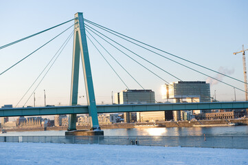 Panorama of the modern buildings of Cologne with bridge in winter and snow.