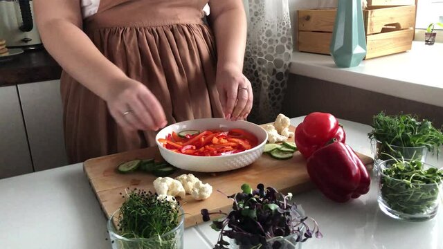 A woman prepares a salad of beautiful delicious vegetables