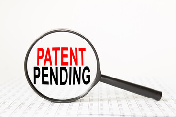 words PATENT PENDING in a magnifying glass on a white background. business concept