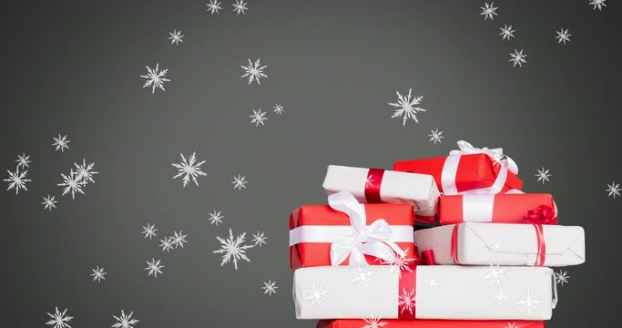 Digital animation of snowflakes falling over christmas gifts against grey background