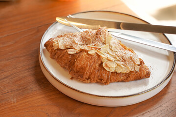 Delicious breakfast with fresh croissants and coffee served with butter on wooden table.