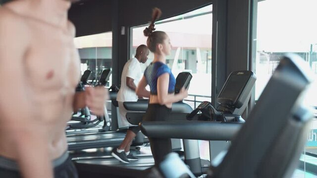 Woman running on running machine at sport gym